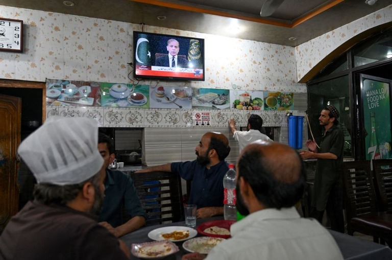 パキスタンのシャリフ首相のテレビ演説を見る人たち＝７日、イスラマバード/Aamir Qureshi/AFP/Getty Images