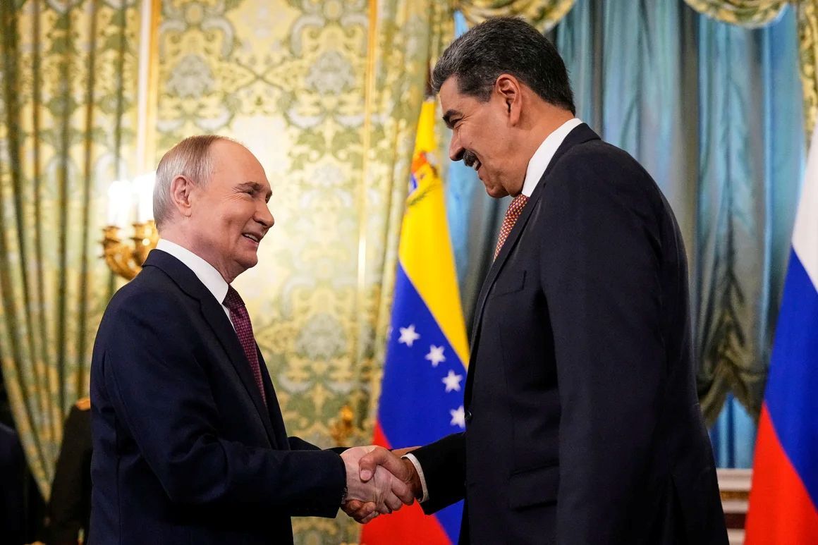 7日、握手を交わすロシアのプーチン大統領(左)とベネズエラのマドゥロ大統領/Alexander Zemlianichenko/Reuters