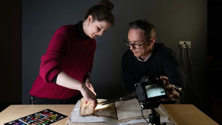 中世の写本の折り目の内側を撮影する保存修復士/Cambridge University Library