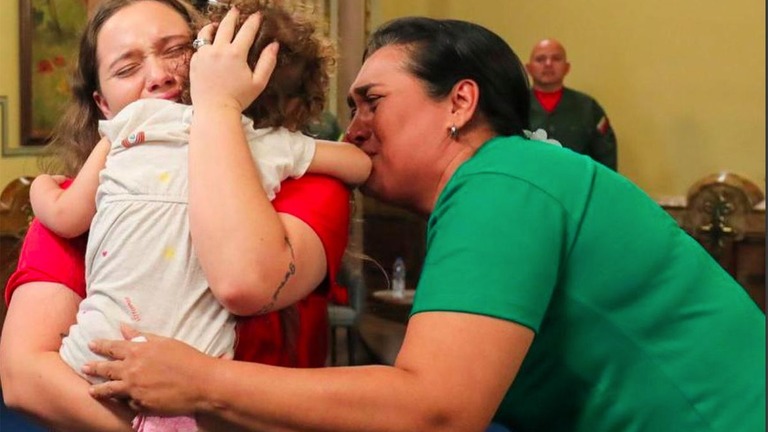 米国からベネズエラに帰還した２歳の女児を抱きしめる母親/Government of Venezuela