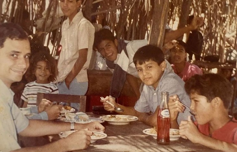 １９８６年、ペルーのピウラで子どもたちと食事するロバート・プレボスト氏（左）/Courtesy Nicanor Palacios