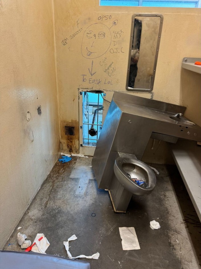収容者らが破って脱走したとみられるトイレの後ろの壁。落書きが残されている/Orleans Parish Sheriff’s Office
