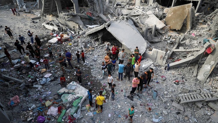 イスラエル軍による空爆の現場を調べるパレスチナの人々＝１８日、パレスチナ自治区ガザ地区北部/Mahmoud Issa/Reuters