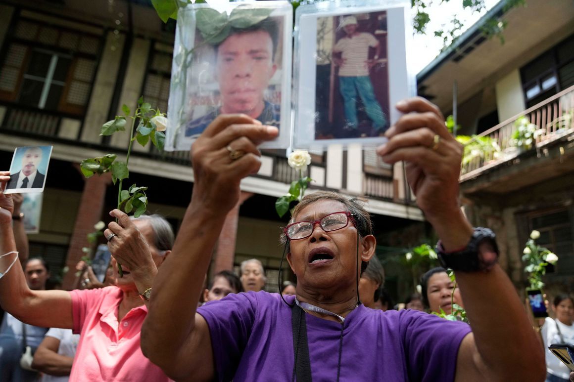 「麻薬戦争」の犠牲者の写真と花を掲げる遺族=3月、フィリピン・ケソン市/Aaron Favila/AP/File