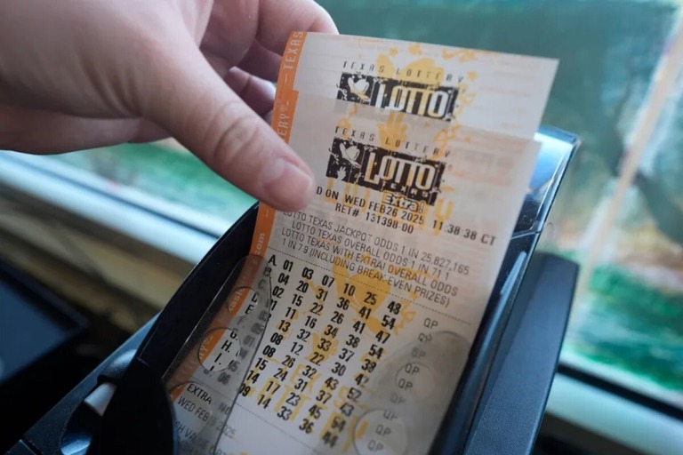 宝くじ売り場にある端末で発行された紙の券を手にする購入者＝２月２６日、テキサス州ダラス/LM Otero/AP/File