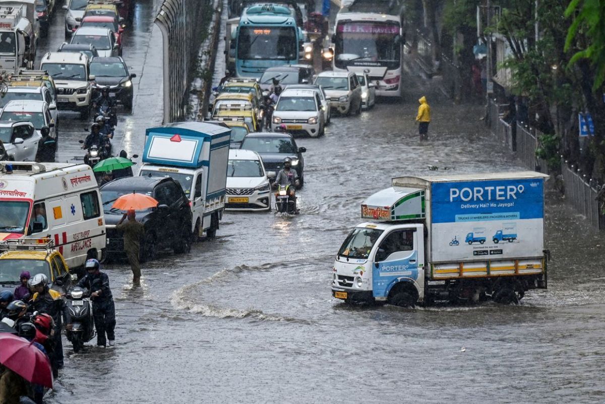 冠水した道路の渋滞に巻き込まれる通勤者/Punit Paranjpe/AFP/Getty Images