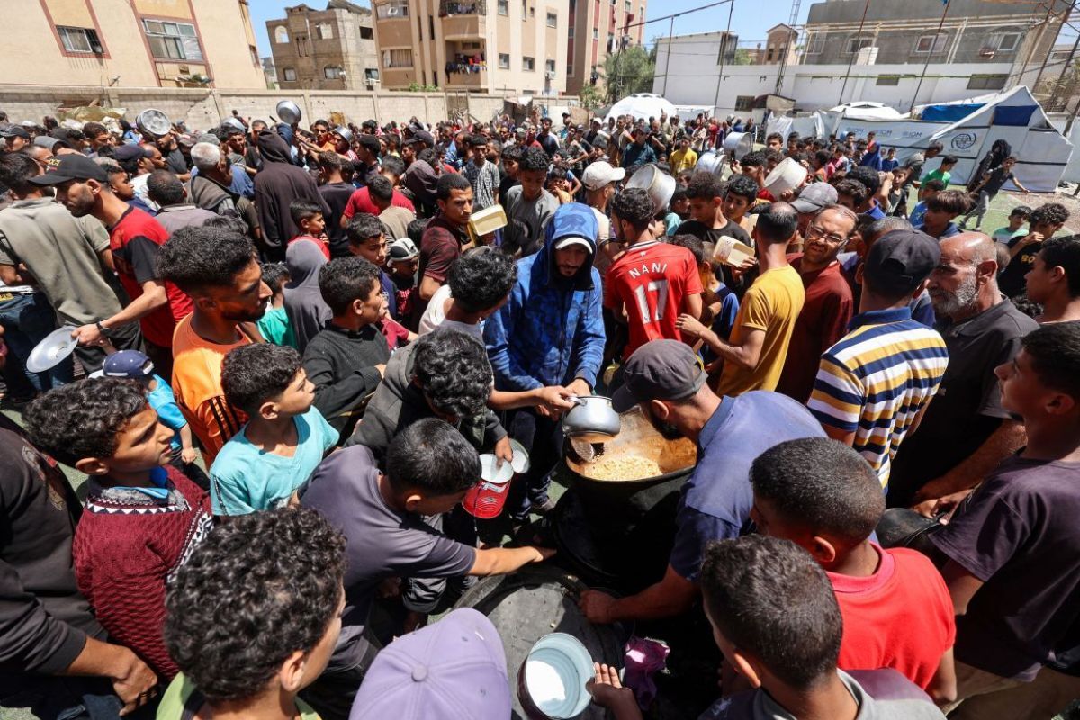 難民キャンプで暖かい食べ物を受け取るパレスチナの人々=5月24日/Eyad Baba/AFP via Getty Images