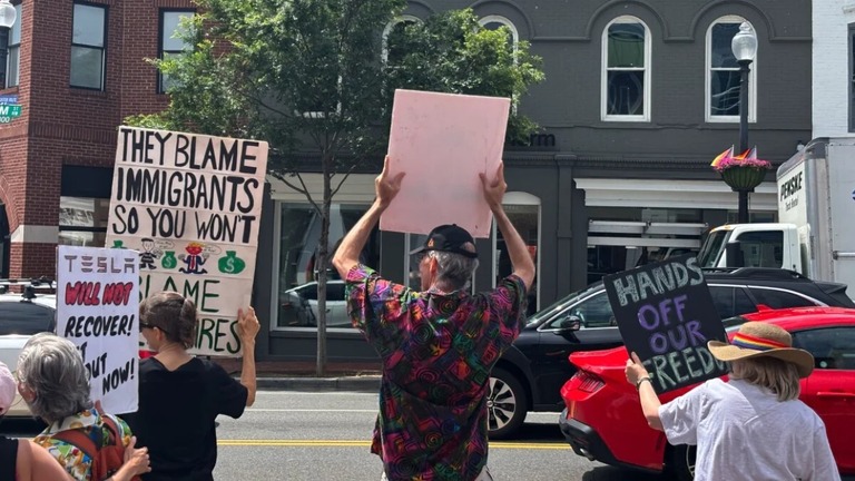 テスラの店舗の前で抗議する人々＝７日、首都ワシントン/Auzinea Bacon/CNN