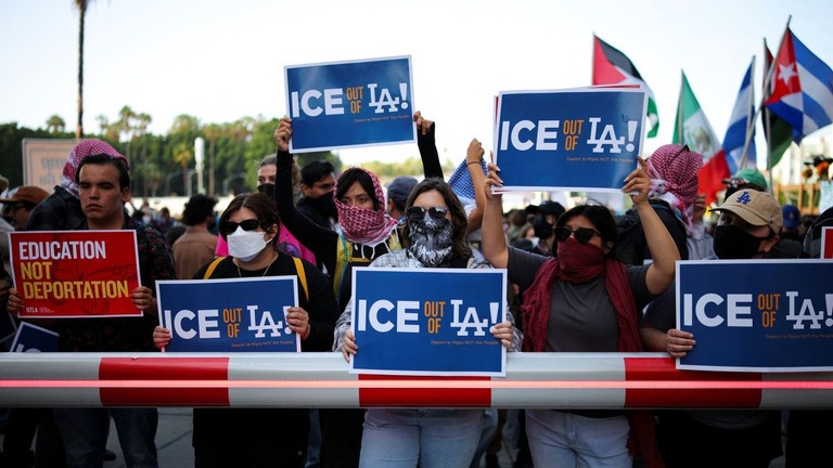 移民税関捜査局（ＩＣＥ）への抗議のメッセージを掲げるロサンゼルスのデモ参加者ら/Daniel Cole/Reuters