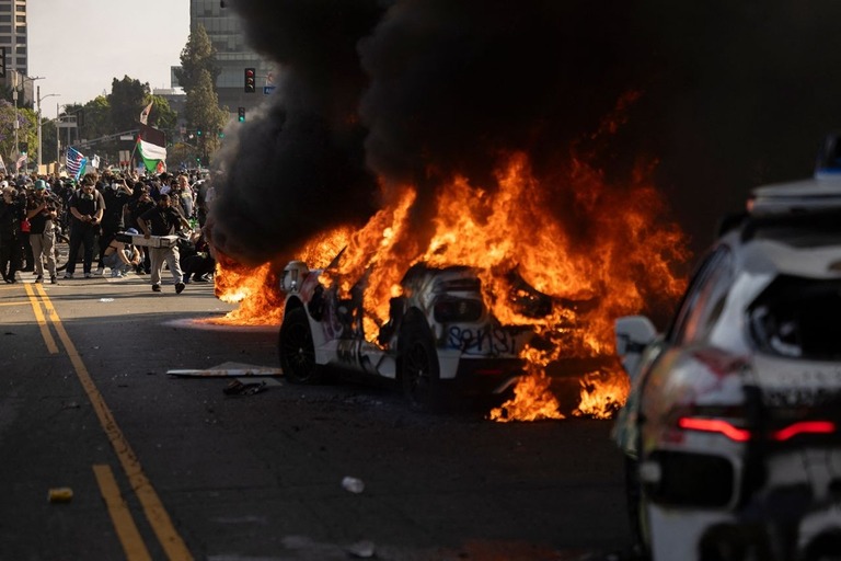 デモ隊と警官が衝突した際に火を付けられた車両＝８日、米ロサンゼルス/Etienne Laurent/AFP/Getty Images