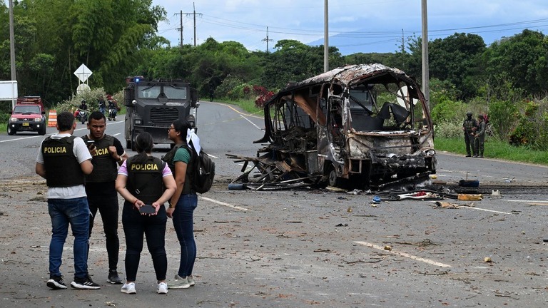 警察前でバスが爆発した現場で捜査を行う警官＝１０日、コロンビア・カウカ県/Joaquin Sarmiento/AFP/Getty Images