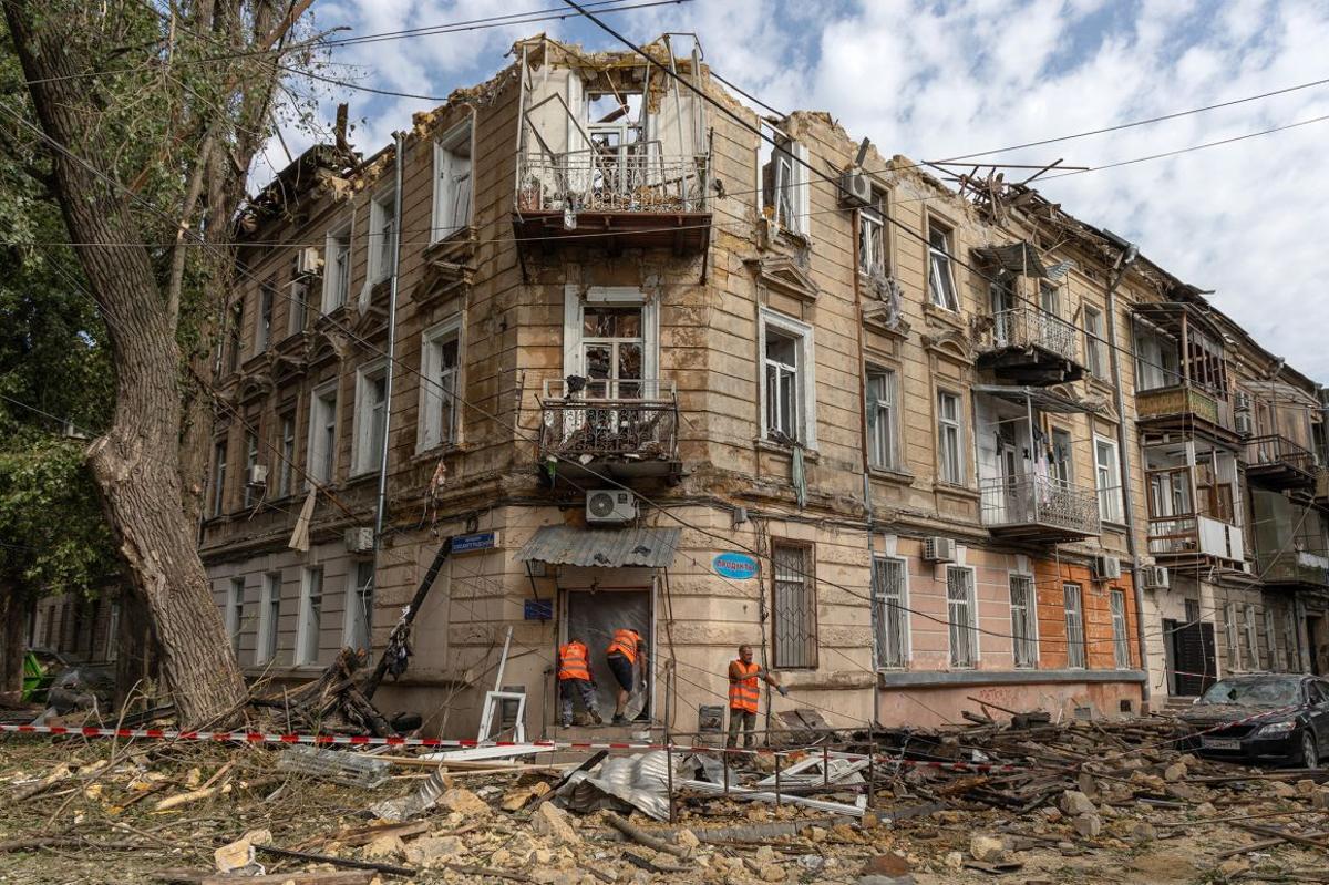 破損した住宅の横でがれきの掃除をする人たち=10日、ウクライナ・オデーサ/Oleksandr Gimanov/AFP/Getty Images