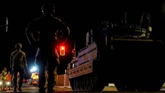 首都ワシントンを移動する車両を見つめる米兵＝１０日