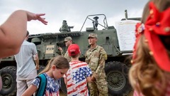 ナショナルモールに止められた軍用車両を見る人たち
