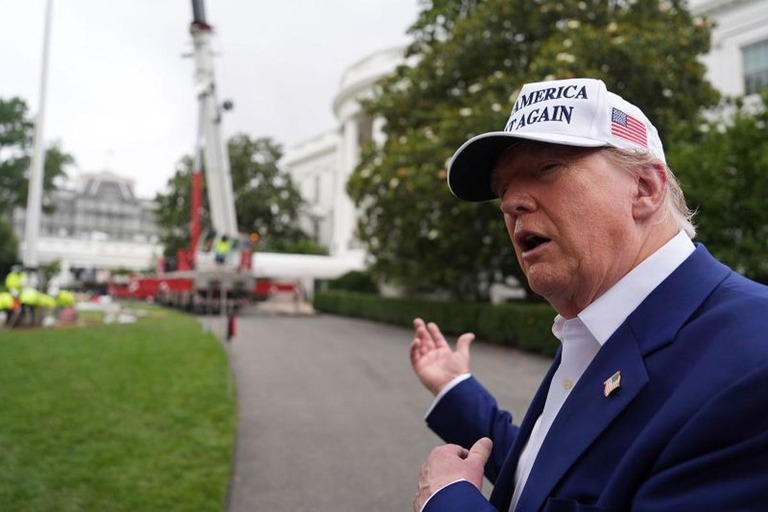 旗ざおの設置作業中に記者団に対応するトランプ米大統領＝１８日/Evan Vucci/AP