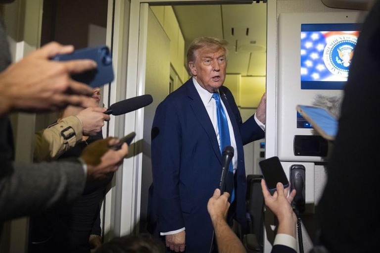 大統領専用機内で記者団に応じるトランプ米大統領＝１６日/Mark Schiefelbein/AP