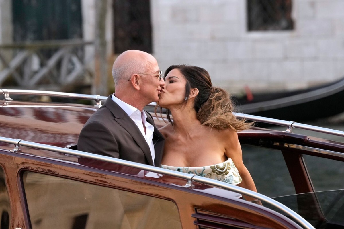 キスを交わすベゾス氏とサンチェス氏。結婚式前の披露宴に出席するため、ベニスのホテル「アマン」を出る際の一コマ=26日/Luca Bruno/AP