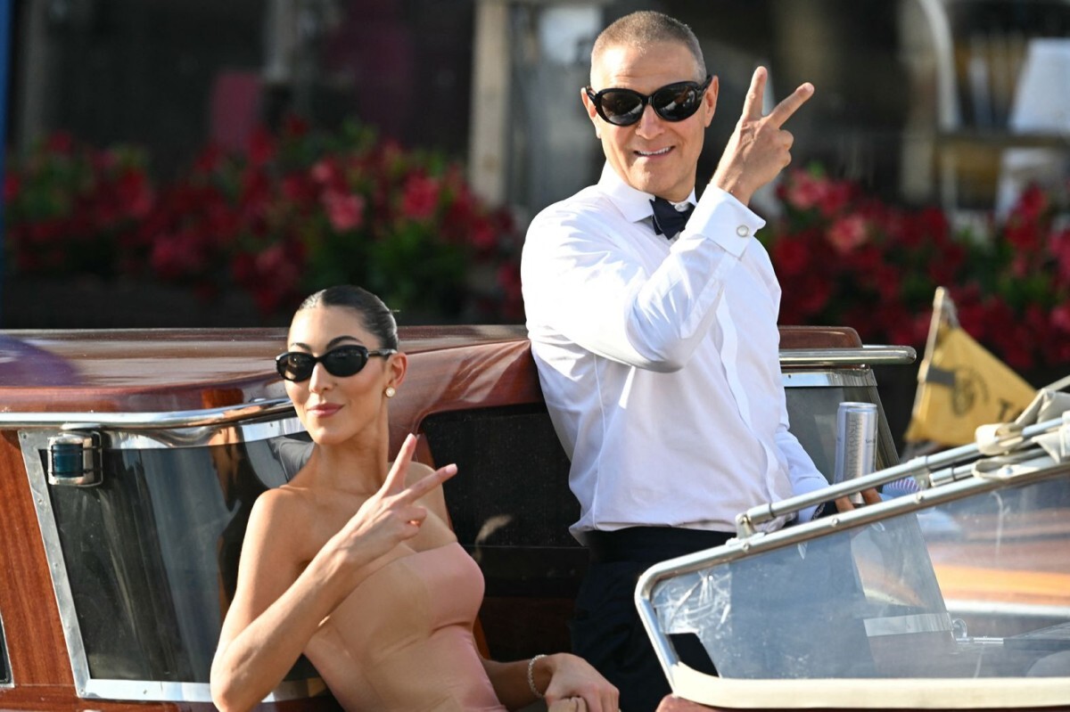 結婚式へ向かう途中、写真撮影のポーズを取るファッションデザイナーのサラ・シュタウディンガーと芸能エージェントのアリ・エマニュエル=27日/Stefano Rellandini/AFP/Getty Images