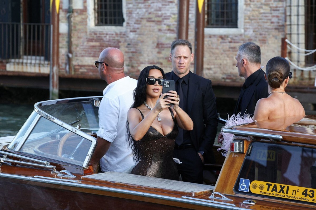 結婚式へ向かうタクシーボートに乗りながら写真撮影するキム・カーダシアン=27日/Guglielmo Mangiapane/Reuters