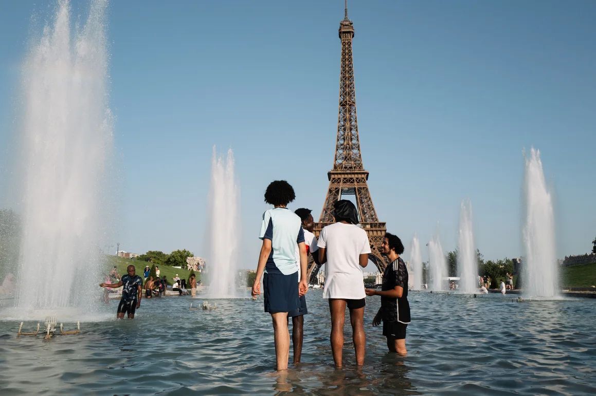 仏パリで高温警戒警報が発せられる中、噴水に入って涼む地元住民と観光客＝１日/Jerome Gilles/NurPhoto/Getty Images