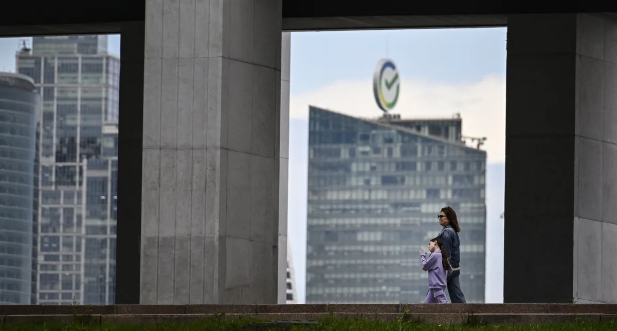 ロシア銀行大手ズベルバンクの前を歩く通行人=6月、ロシア首都モスクワ/Alexander Nemenov/AFP/Getty Images