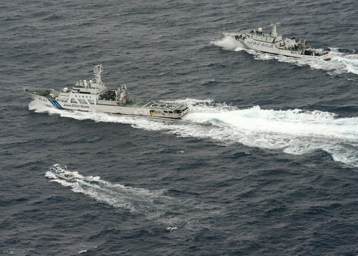 東シナ海を航行する中国の海洋監視船「海監66号」(上)が日本の漁船(下)に近づこうとするなか、海監66号の横を航行する海上保安庁の巡視船=2013年4月/Kyodo/Reuters