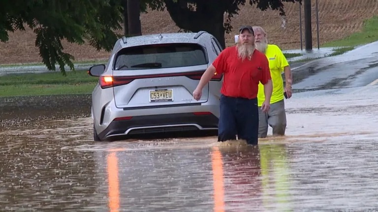 水没したペンシルベニア州ランカスター郡の道路を歩く人々＝１４日/WPMT