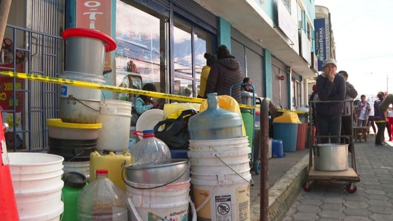 給水車を待つキトの住民/CNN