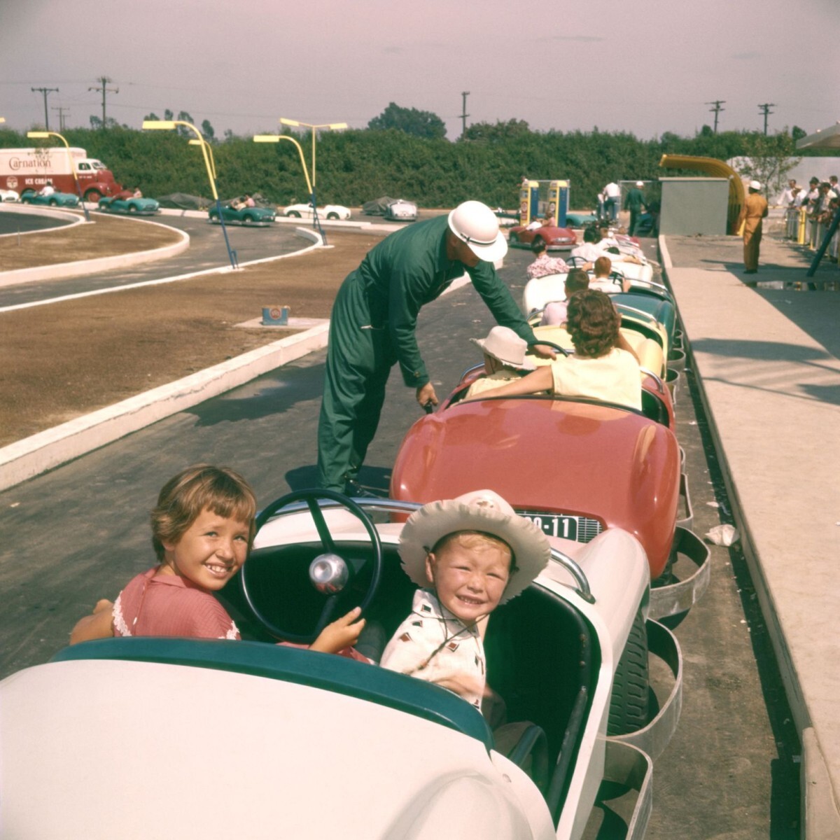 車のアトラクション「オートピア」に乗る前に写真撮影のポーズを取る子どもたち/Loomis Dean/The LIFE Picture Collection/Shutterstock