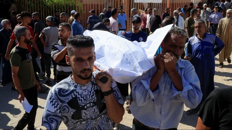 死亡したパレスチナ人の遺体を運ぶ人々＝１６日、ガザ地区南部ハンユニス/Hatem Khaled/Reuters