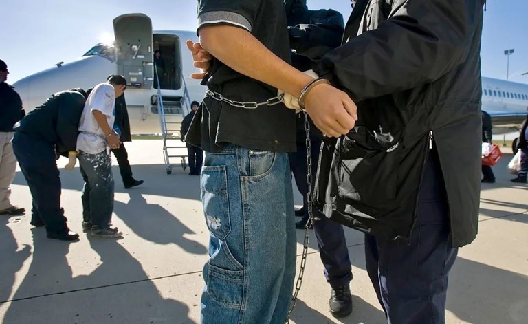 移民税関捜査局（ＩＣＥ）のチャーター機搭乗前に手首と足首を拘束される不法移民＝２０２４年１２月２日、カンザスシティ国際空港/Kansas City Star/Tribune News Service/TNS/Getty Images