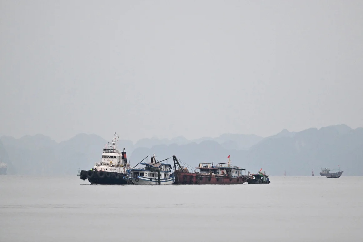 港にえい航される転覆した観光船/Nhac Nguyen/AFP/Getty Images