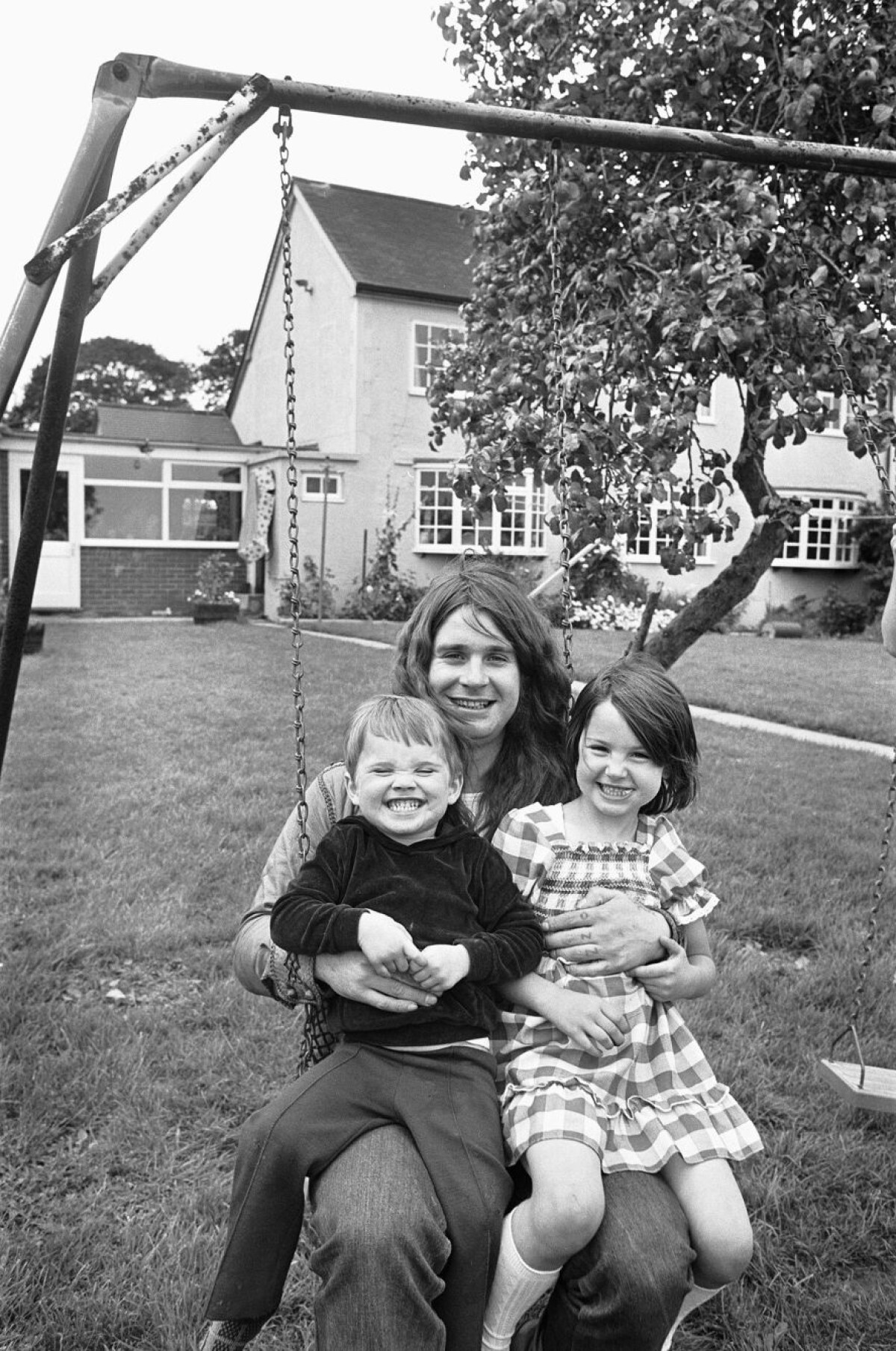 オズボーンさんが子どものルイさん、ジェシカさんと一緒にブランコに座っている1970年の写真。オズボーンさんは2度結婚しており、結婚相手の子ども1人を含め6人の子どもがいる/Mirrorpix/Getty Images