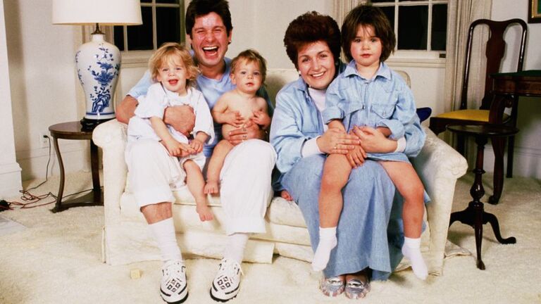 オズボーンさんと妻のシャロンさん。1990代初頭に自宅で3人の子どもたち(ケリーさん、ジャックさん、エイミーさん)と一緒にポーズを取る様子/Dave Hogan/Hulton Archive/Getty Images