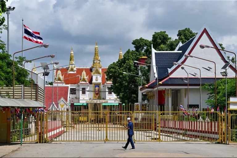 国境検問所の閉ざされたゲートの近くを歩く男性＝タイ・カンボジア国境/Tang Chhin Sothy/AFP/Getty Images