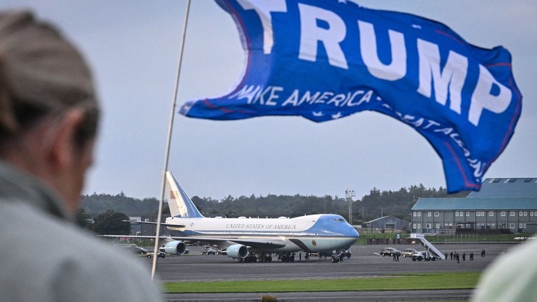 スコットランド、グラスゴー南郊の空港に着陸した米大統領専用機をトランプ氏支持の旗が出迎える/Andy Buchanan/AFP/Getty Images