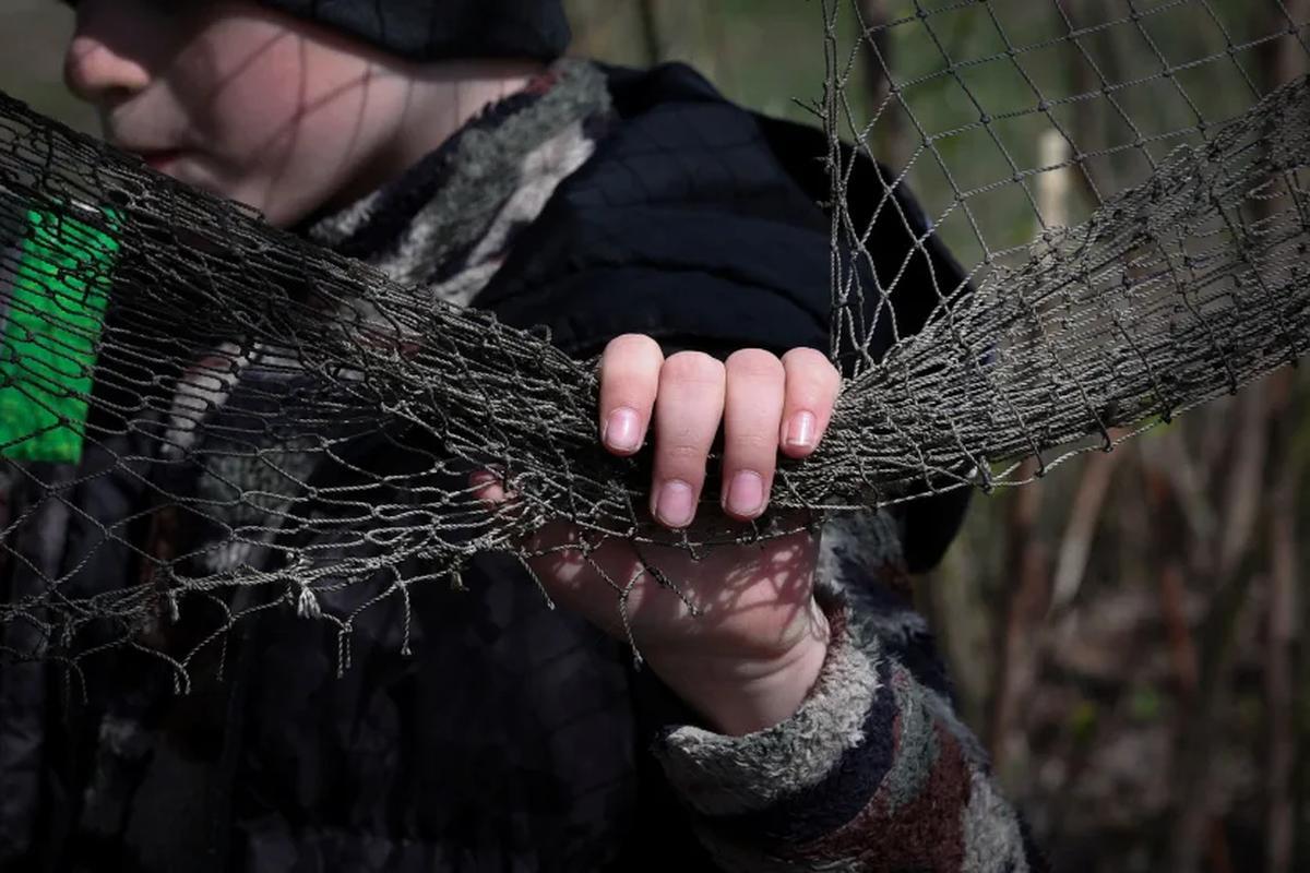 即席の対ドローン用ネットを手にする6歳の少年=4月、ウクライナ・ハルキウ州/Violeta Santos Moura/Reuters