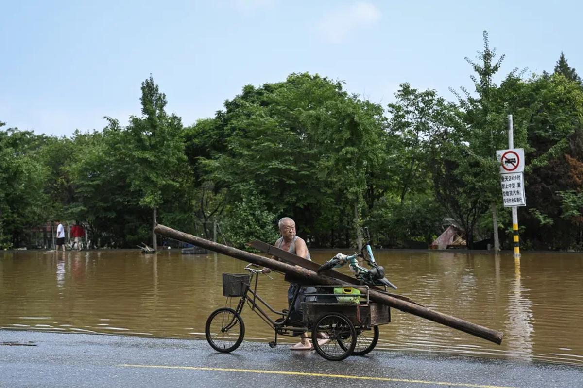 洪水後、所持品を搬送する高齢の男性/Jade Gao/AFP/Getty Images