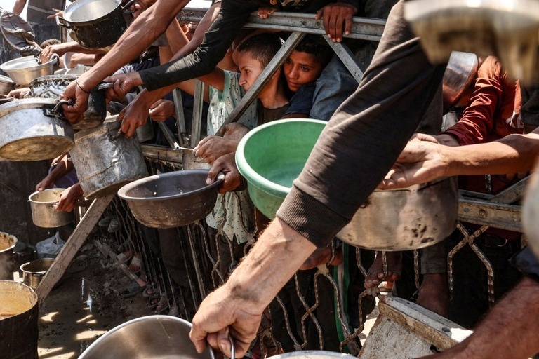 レンズマメのスープの配給所に押しかけるガザ住民＝２７日/Omar Al-Qattaa/AFP/Getty Images