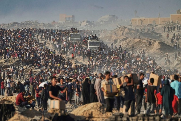 国連機関の車列から援助物資を運ぶガザ住民＝６月１６日/Jehad Alshrafi/AP