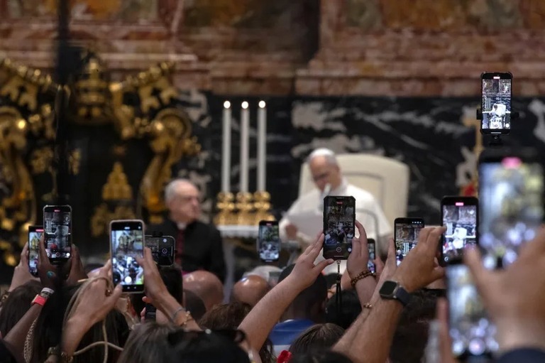 ローマ教皇レオ１４世のミサの様子を撮影する信者ら/Maria Grazia Picciarella/Middle East Images/AFP/Getty