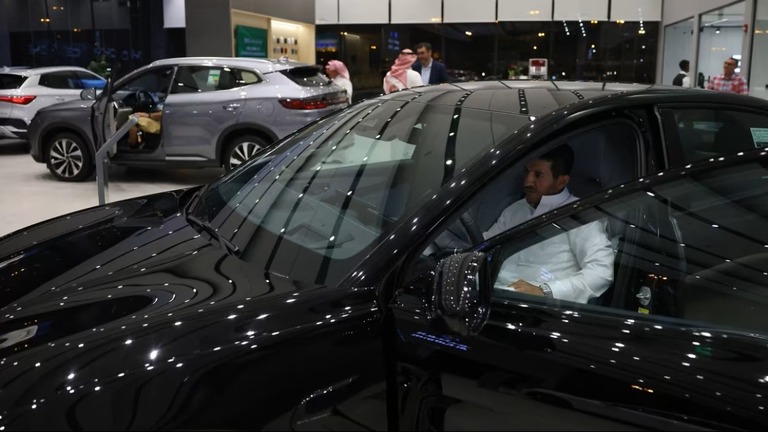 ショールームで電気自動車を吟味する男性＝２０２４年６月、サウジアラビア首都リヤド/Fayez Nureldine/AFP/Getty Images
