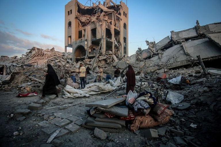 イスラエル軍による空爆の後、荒廃したガザ市内を歩くパレスチナ人たち/Saeed M. M. T. Jaras/Anadolu/Getty Images