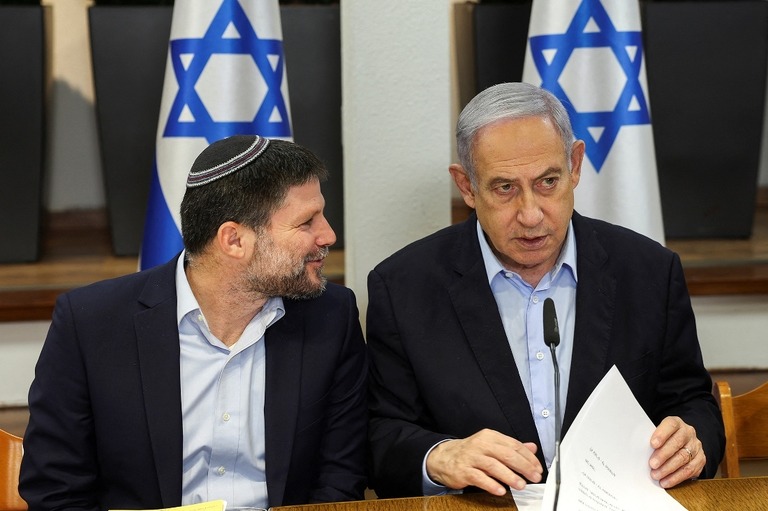 閣僚会議で言葉を交わすイスラエルのネタニヤフ首相（右）とスモトリッチ財務相/Ronen Zvulun/Pool/Reuters