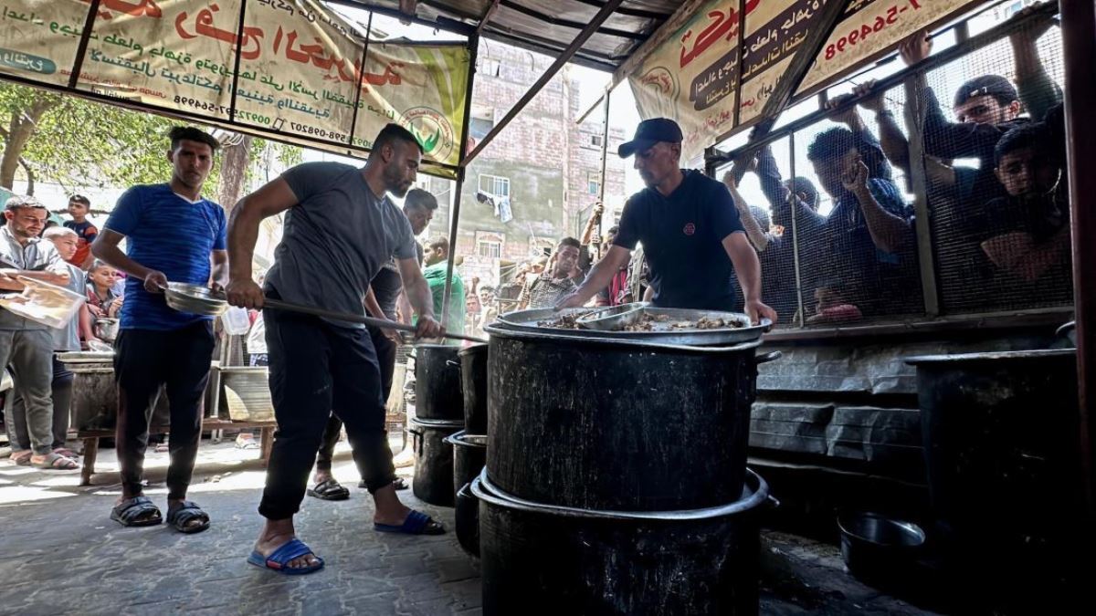 家族のために支援団体からの食事を受け取ろうと待機する人々＝３日、パレスチナ自治区ガザ地区南部/Doaa Albaz/Anadolu/Getty Images